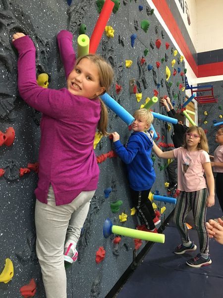 students climbing rockwall
